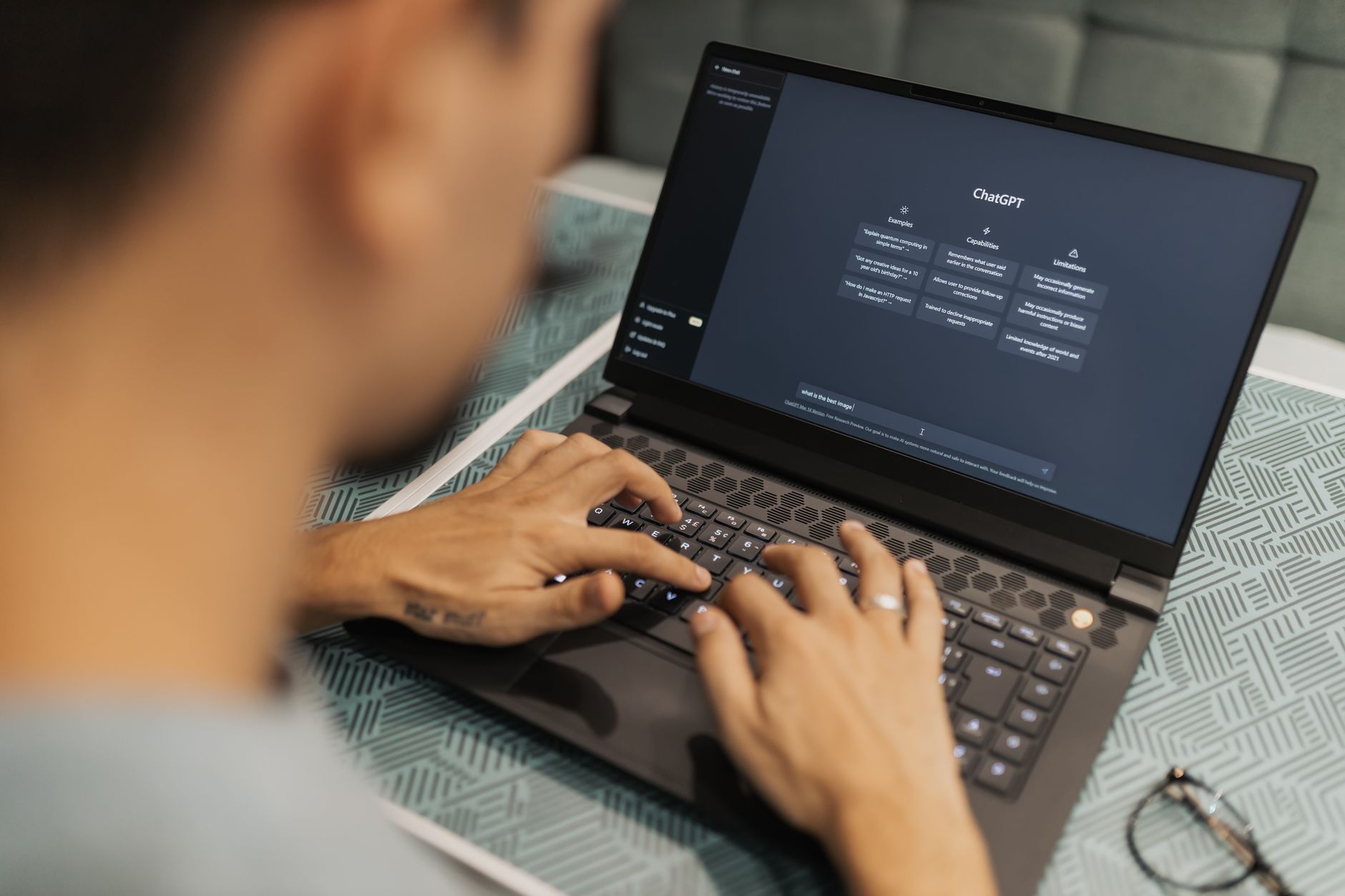 Person typing on laptop showing an AI research chat interface with citations