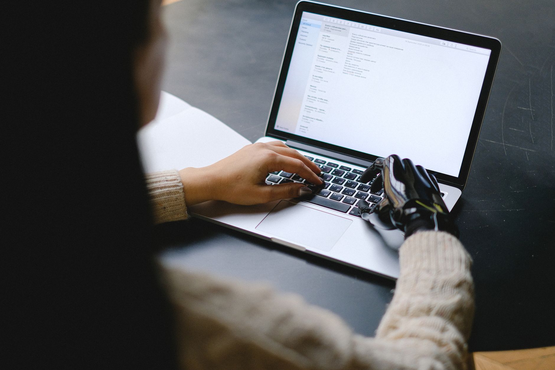 Person coding on laptop with AI assistant interface open on screen