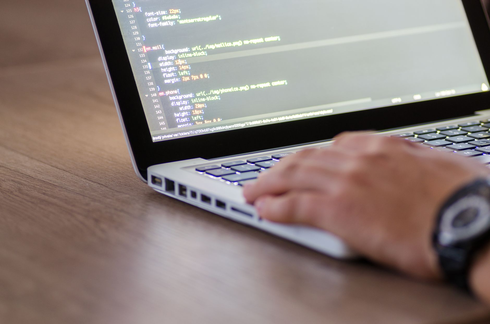 Developer typing code in an AI code editor on a laptop screen