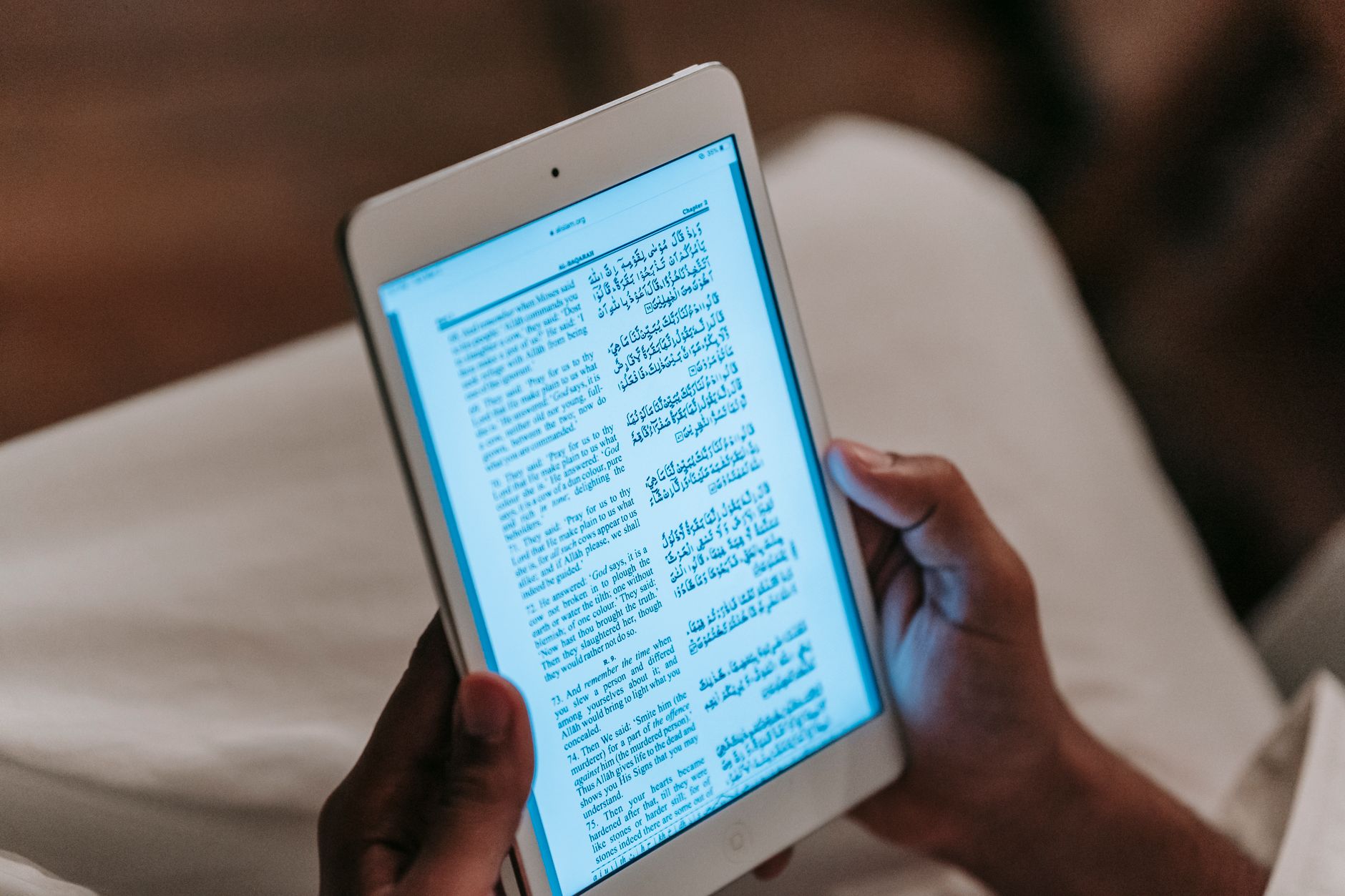 A person reading an article on a tablet with highlighted citation numbers and source links visible.